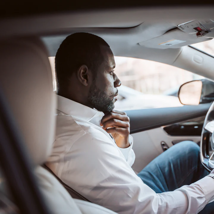 A man in a white shirt driving to work