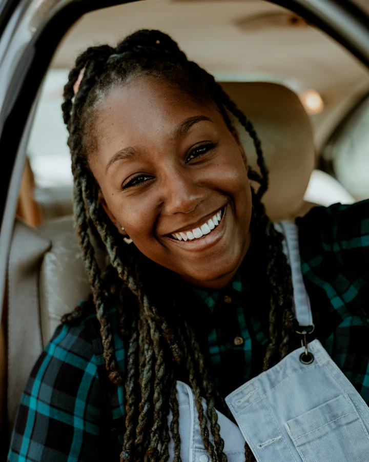 A smiling commuter in the back seat of a car